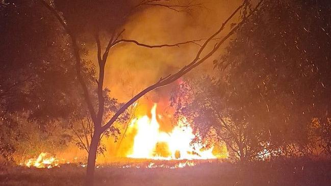 A contribution to the online Dubbo Crime Page of a car in flames on dry grass and near power lines.