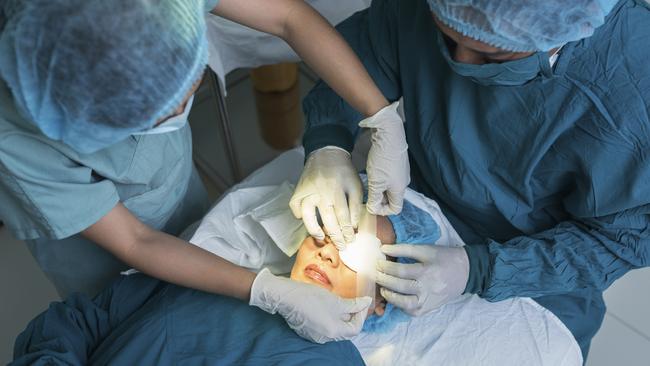 Nurse covering eye of patient by medical plasterPicture: istock