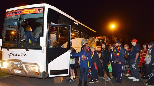 Adelaide fans boarding one of the two buses heading off to Melbourne on Thursday night. Picture: Brenton Edwards