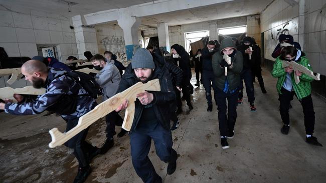 A military instructor teaches civilians, holding wooden replicas of Kalashnikov rifles, as they take part in a training session, in the Ukrainian capital of Kyiv, amid fears of a potential invasion by Russian troops. Picture: AFP