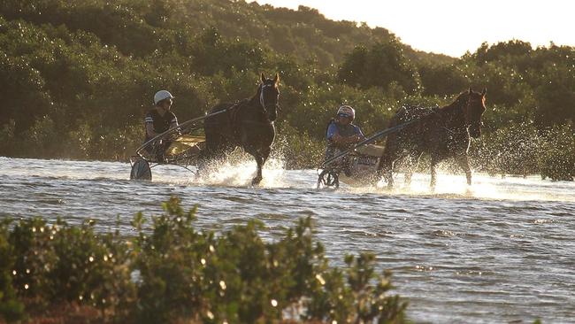 Jayden Brewin (left) warms up a horse by wading through the shallows at Port Gawler in 2018. Picture: Graham Fischer