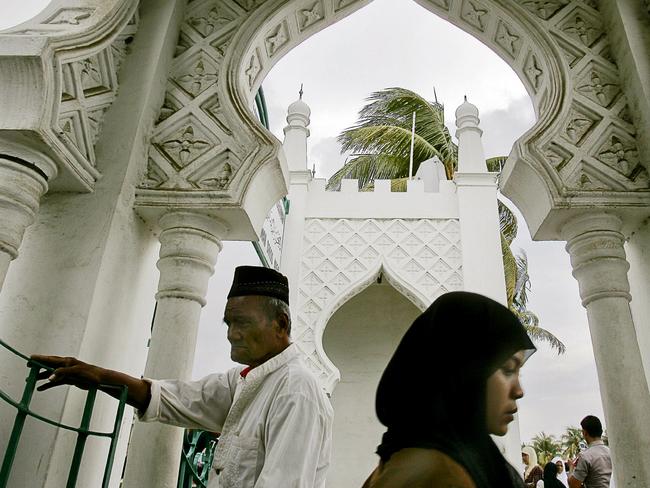 Acehnese men and women enter the main mosque in Banda Aceh. The conservative Islamic province is the only one in Indonesia that enforces Sharia law.