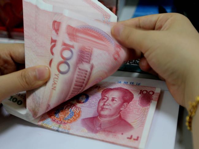 A teller counts yuan banknotes in a bank in Lianyungang, east China's Jiangsu province on August 11, 2015. China's central bank on August 11 devalued its yuan currency by nearly two percent against the US dollar, as authorities seek to push market reforms and bolster the world's second-largest economy. CHINA OUT AFP PHOTO