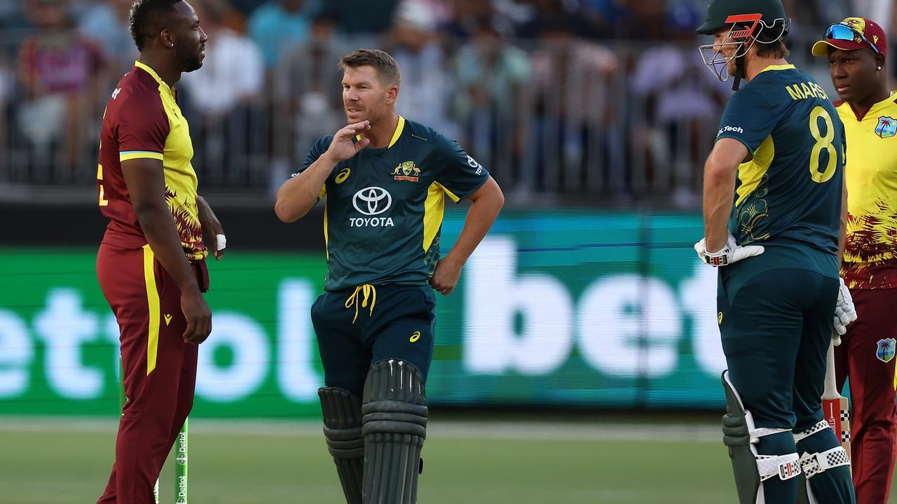 David Warner holding his jaw after being struck by a delivery from Andre Russell (Photo by Paul Kane/Getty Images)