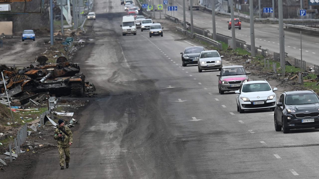 Cars driving past a destroyed Russian tank on the outskirts of Kyiv. Picture: AFP.