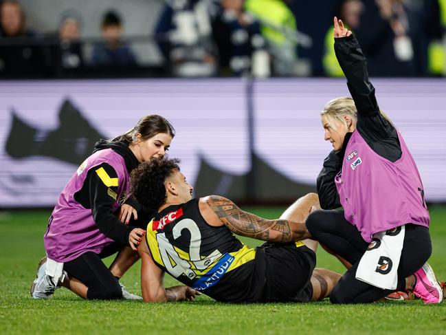 Mykelti Lefau of the Tigers is attended to by medical staff following a knee injury. Photo by Dylan Burns/AFL Photos via Getty Images.