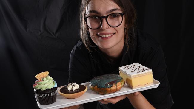 Staff member Janine Fleischfresser with some amazing vegan treats made by Flour of Life Bakery at Helensvale. Photo: Steve Holland