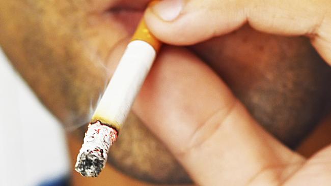 Close up portrait of young man smoking cigarette