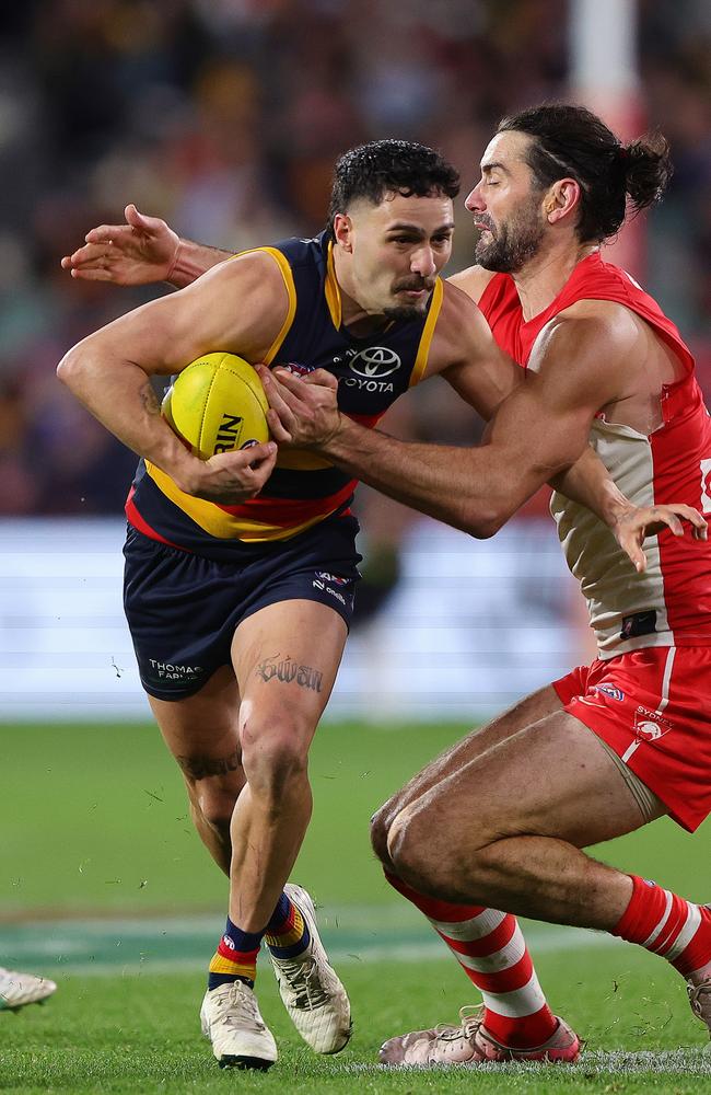 Izak Rankine escapes the clutches of Brodie Grundy. Picture: Sarah Reed/AFL Photos via Getty Images.
