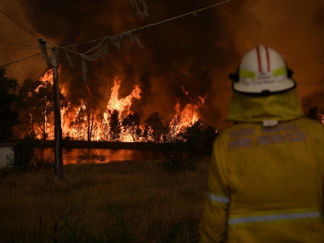 NSW Rural Fire Service crews watch on as on as the Gospers Mountain fire impacts the Bilpin Fruit Bowl. Picture: AAP/Dan Himbrechts