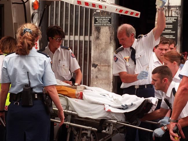 Ambulance officers working to revive a critically injured man at the scene of the shooting at the Blackmarket Cafe in Chippendale.