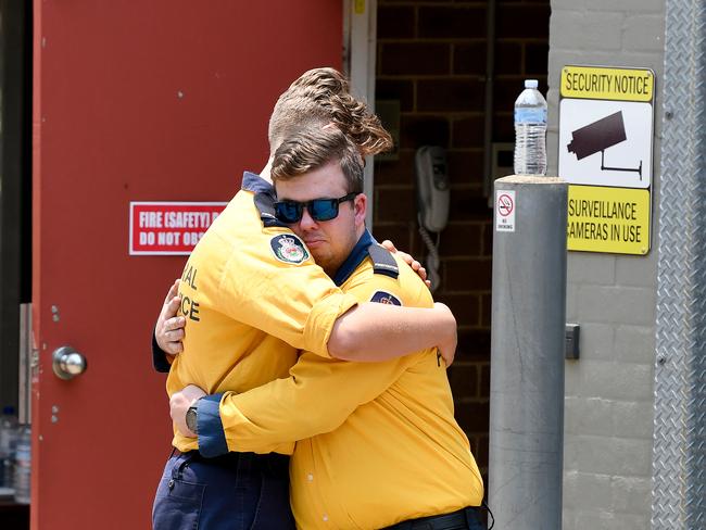 Fellow firefighters console each other. Picture: AAP