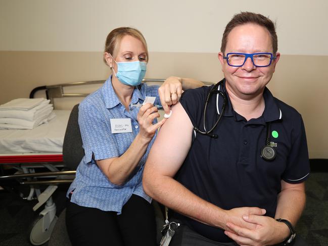 Alison Clancy a nurse injects the dr with the vaccine .Associate Professor Paul Griffin, an infectious disease expert, is getting his AstraZeneca vaccine at the Mater Hospital today. Pic Annette Dew