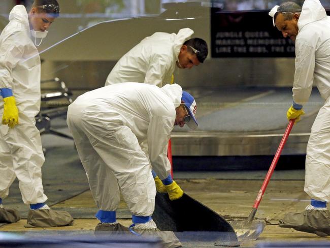 A hazmat crew cleans up baggage claim Terminal Two after multiple people were shot. Picture: AP