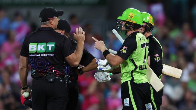 Sam Billings and Matthew Gilkes of the Thunder speak to the umpires as they wait for the DRS call. Photo by Mark Kolbe Photography/Getty Images.