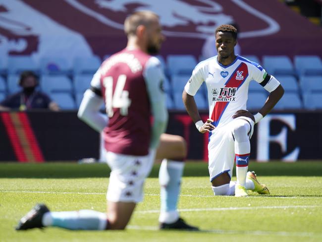 Crystal Palace's Ivorian striker Wilfried Zaha kneels before the clash with Aston Villa.