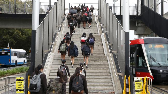 Students at the Sydney Light Rail Moore Park stop on their way to school today. Picture: Getty