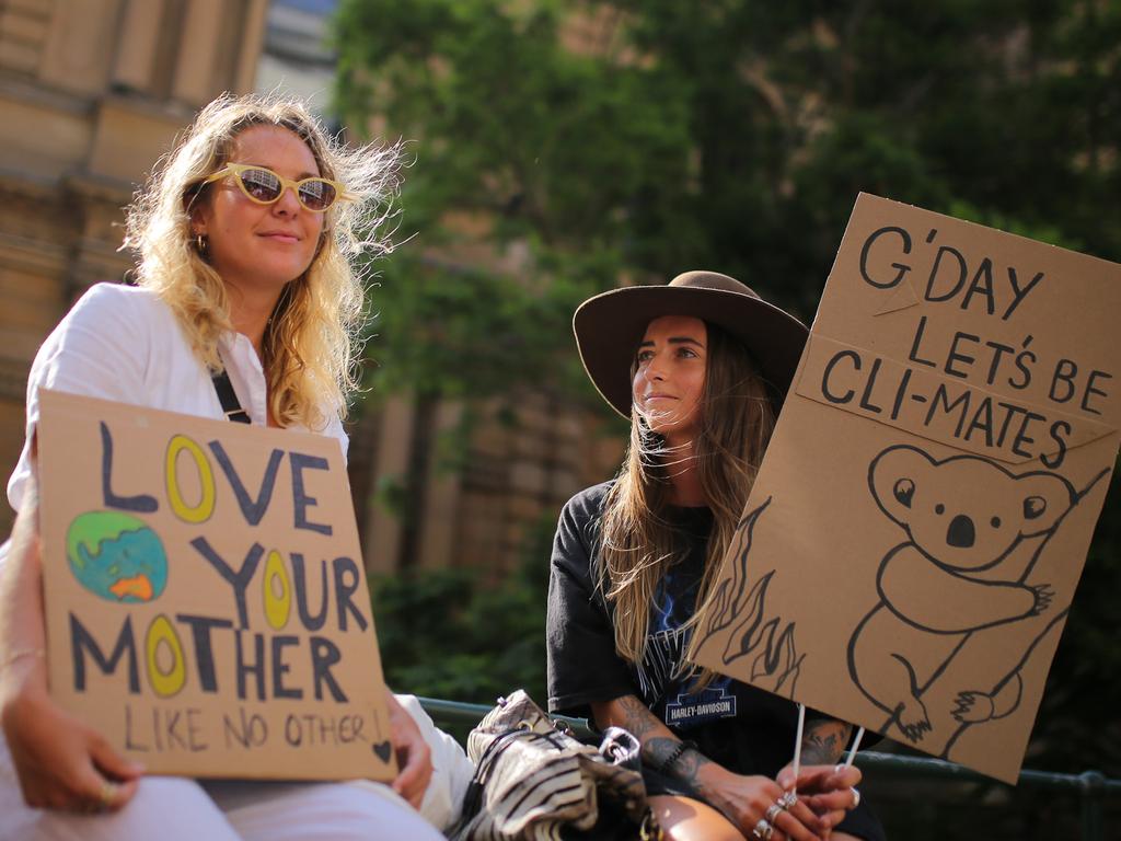 Protesters hold placards during a 'Sack ScoMo!' climate change rally in Sydney, Friday, January 10, 2020. (AAP Image/Steven Saphore)