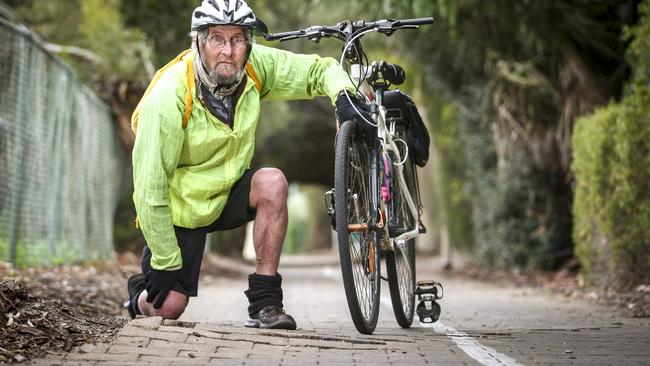 Cyclist Bob Fleming at a damaged section of the Mike Turtur Bikeway where the pavers are lifting due to tree roots. Picture: AAP/Mike Burton