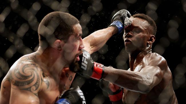 Robert Whittaker exchanges with Israel Adesanya at UFC 271. Carmen Mandato/Getty Images/AFP