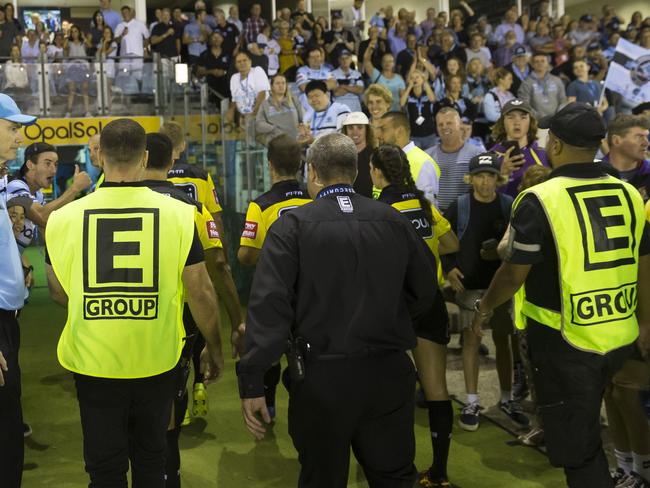 Referees are escorted from the field after awarding 33 penalties in the Sharks v Storm game.