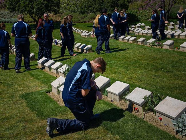 In memory of ... An Australian school student from NSW kneels in front of one grave stone of mostly Australian soldiers who died during the Gallipoli Campaign at Shrapnel Valley Cemetery near Anzac Cove. Picture: Carsten Koall/Getty Images