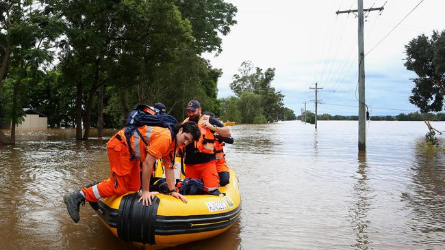 SES land a boat in front of residential homes after surveying floodwaters in Windsor. Picture: Lisa Maree Williams.