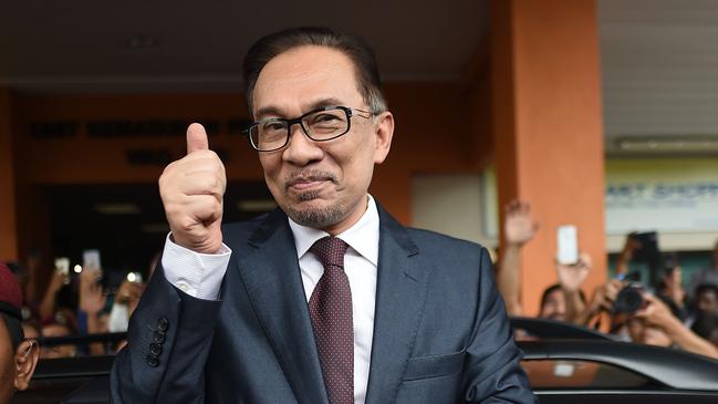 Jailed former opposition leader and current Federal opposition leader Anwar Ibrahim greets supporters after his release from the Cheras Hospital Rehabilitation in Kuala Lumpur on May 16, 2018. The release of Anwar from prison marks yet another sharp turn in a roller-coaster political life that has left a profound mark on Malaysian politics and society. Anwar was pardoned and released on on May 16, 2018 after serving three years for a sodomy conviction widely considered a railroad job and now quashed following the stunning defeat of a Malaysian regime that had ruled for six decades.  / AFP PHOTO / MOHD RASFAN