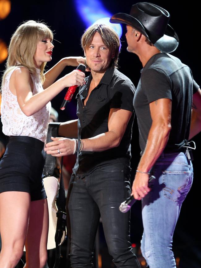 Taylor Swift is joined on stage by Keith Urban and McGraw at the CMA festival. Picture: Dean Chapple