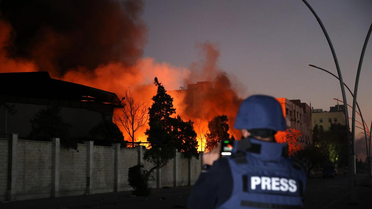 A member of the press documents a fire burning following explosions at a security compound that houses the Syrian Military Intelligence Interrogation Division in Damascus, Syria. Picture: Ali Haj Suleiman/Getty Images