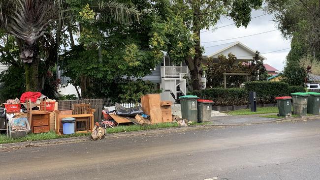 Flood-damaged possessions line Tumbulgum Rd in Murwillumbah. Picture: Liana Walker