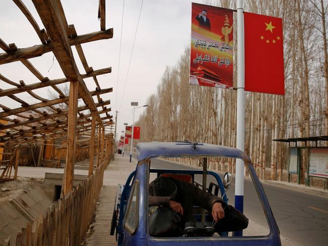 A poster showing Chinese President Xi Jinping lines a road in the Xinjiang Uighur Autonomous Region. PHOTO: THOMAS PETER/REUTERS