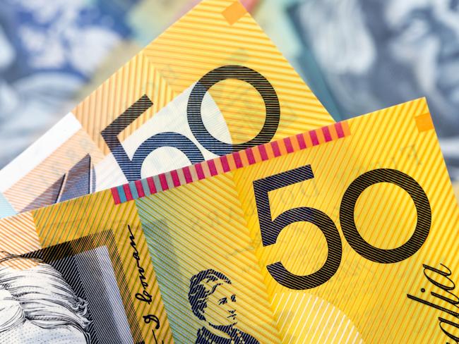 Australian money background.  Focus on foreground, blurred faces beneath. Fifty dollar notes generic