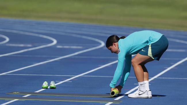 Injured striker Sam Kerr rolls up the Matildas’ warm-up gear while the rest of Australia’s squad trains. Picture: Lachie Millard