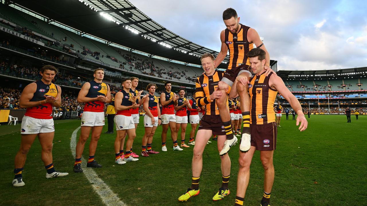 James Sicily and Luke Breust chair Jack Gunston off the ground in front of the Crows. (Photo by Morgan Hancock/AFL Photos/via Getty Images)