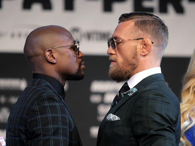 Boxer Floyd Mayweather Jr. (L) and Connor Mcgregor face-off during a media press conference August 23, 2017 at the MGM Grand in Las Vegas, Nevada.  Mayweather, the 40-year-old undefeated former welterweight boxing champion, has been lured out of retirement to face McGregor, a star of mixed martial arts' Ultimate Fighting Championship. The two men meet in a 12-round contest under boxing rules on August 26th that is tipped to become the richest fight in history.  / AFP PHOTO / John Gurzinski