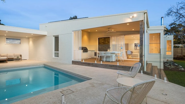 A north-facing pool, covered deck with a built-in barbecue and fan, outdoor firepit with a sitting area and an outdoor shower make for a spectacular back garden.