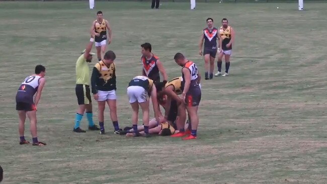 Players and spectators watched on as the man was left unconscious and waiting for an ambulance. Picture: RMFL