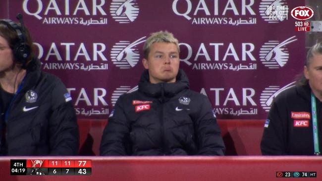 Jack Ginnivan reacts seeing himself on the big screen while injured during Collingwood's loss to Sydney.