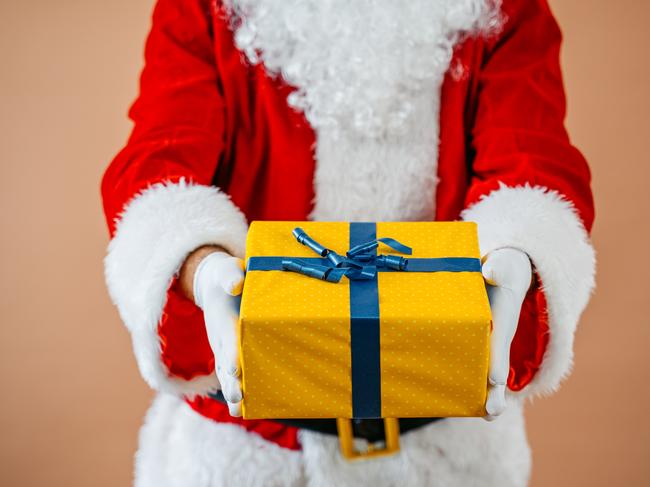 Portrait of a Santa Claus holding a gift.