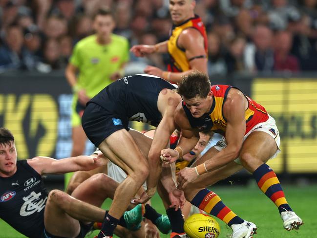 MELBOURNE, AUSTRALIA - APRIL 13: Matt Crouch of the Crows bumps Jack Carroll of the Blues during the round five AFL match between Carlton Blues and Adelaide Crows at Marvel Stadium, on April 13, 2024, in Melbourne, Australia. (Photo by Quinn Rooney/Getty Images)