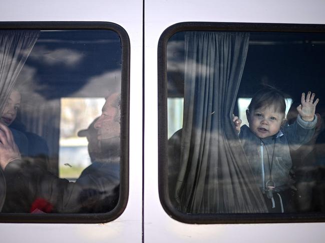 A Ukrainian refugee baby waves from a minibus taking him and his mother further into Moldova after crossing the Ukrainian-Moldovan border in Palanca. Picture: AFP