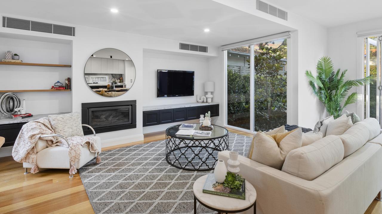 The light-filled living area includes soaring ceilings and indoor-outdoor flow, with full-width bi-fold doors connecting the interior of the character home to the alfresco entertaining space.