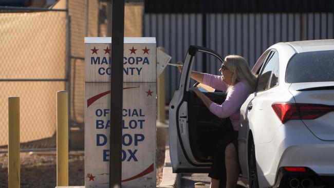 A voter drops off their ballot in a dropbox at Maricopa County Tabulation and Elections Center.