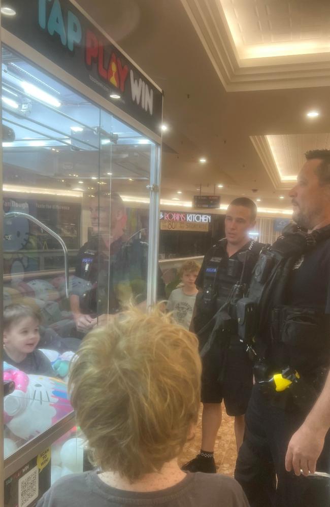 Ethan Hopper, 3, smiles at police after yelling “free toys” to onlookers at Capalaba Shopping Centre when he became trapped inside a claw machine.