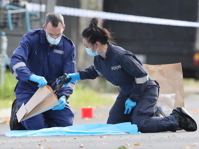 Police remove a gun from the scene on Friday. Picture: David Crosling