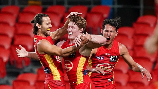 Matthew Rowell of the Suns (centre) celebrates a goal during the Round 2 AFL match between the Gold Coast Suns and the West Coast Eagles at Metricon Stadium on the Gold Coast, Saturday, June 13, 2020. . (AAP Image/Dave Hunt)