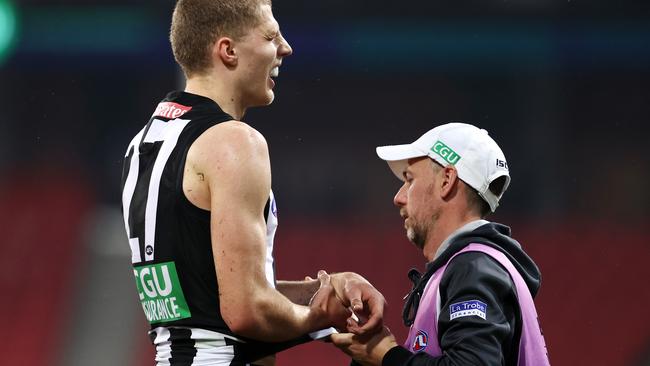 Will Kelly is assessed after injuring his arm in Collingwood’s win over Hawthorn.