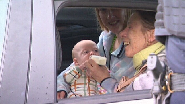 Mum feeds her four-month-old baby in the back of a police car after he was taken when her car was stolen. Picture: NINE NEWS