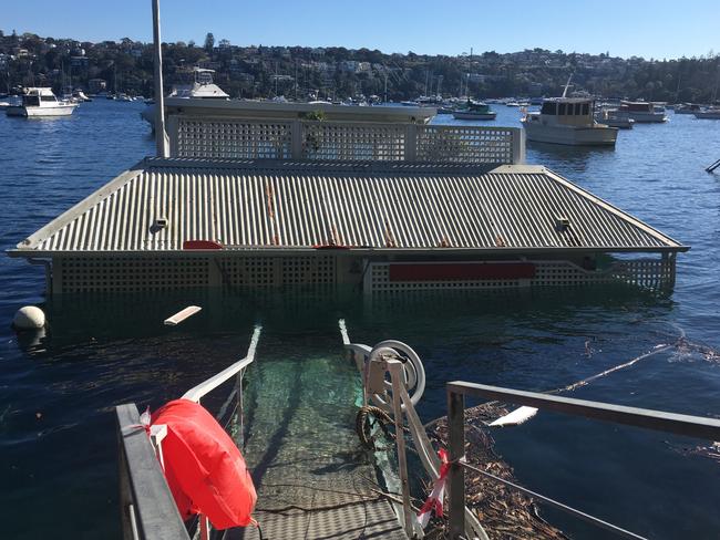 The houseboat lays, semi-submerged, in Pearl Bay.